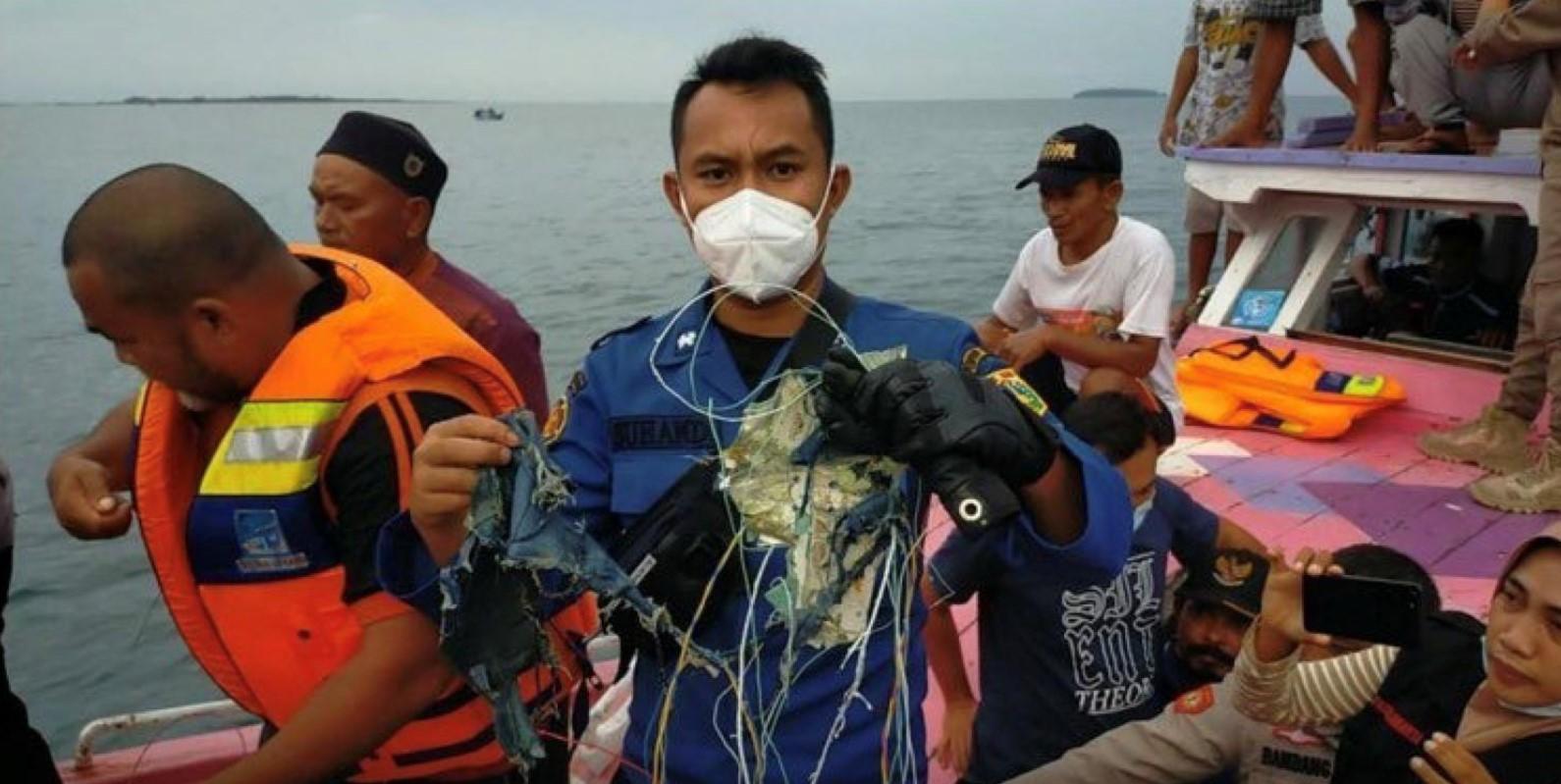 A member of the rescue team looking for an Indonesian plane that lost contact after taking off from the capital Jakarta holds suspected debris, at sea, January 9, 2021. - Avaz