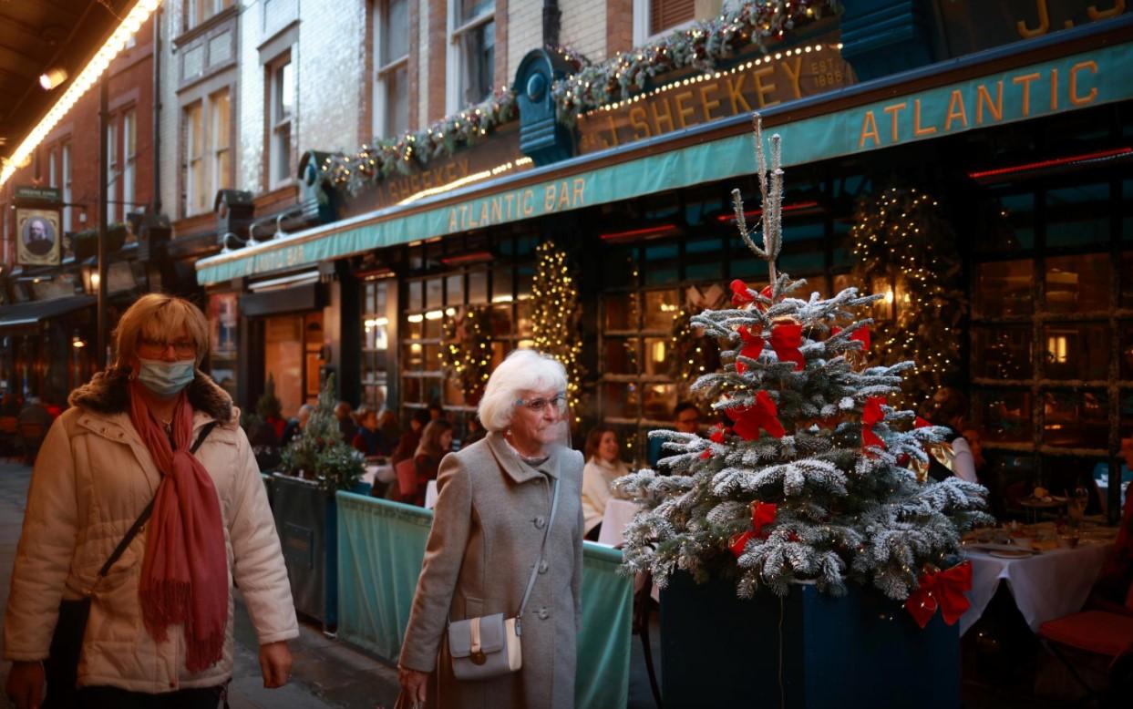 FILE PHOTO: Women walk outside a restaurant following the coronavirus disease (COVID-19) outbreak in London, Britain, December 15, 2020. - Avaz