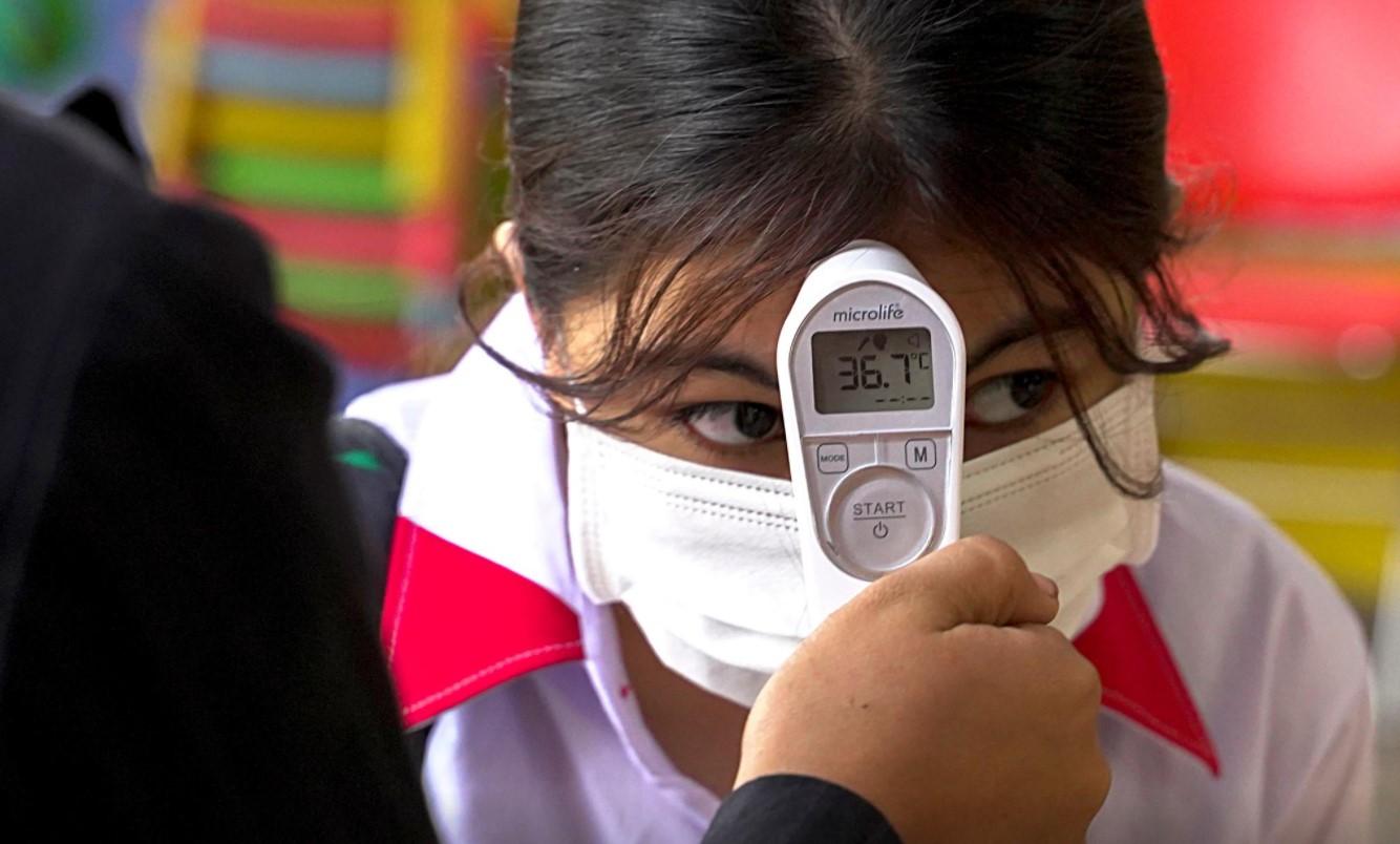 A student from the Sovannaphumi school wearing a face mask has her temperature checked as Cambodia reopen schools and museums after months of shutdown due to surging of the coronavirus disease (COVID-19) in Phnom Penh, Cambodia, January 4, 2021. - Avaz