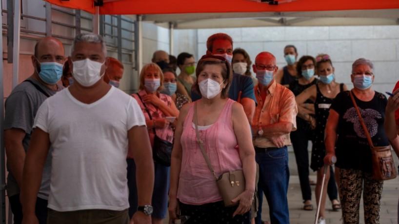 People wearing face masks queue up to be tested for COVID-19, outside a local clinic in Santa Coloma de Gramanet in Barcelona, Spain, Tuesday, Aug. 11, 2020. - Avaz