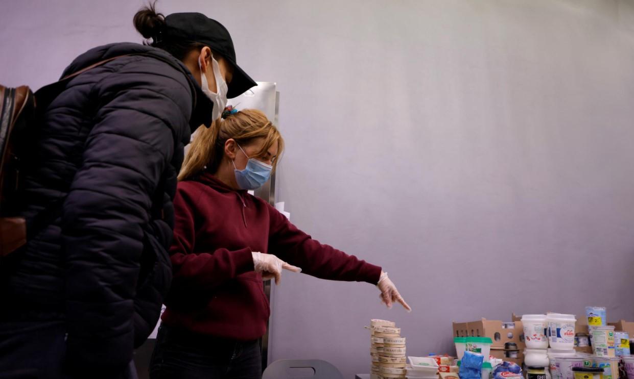 A volunteer shows food to a student during a distribution organised by French charity food distribution association "Les Restos du Coeur" (Restaurants of the Heart) at a CROUS student residence in Paris during the coronavirus disease pandemic in France, February 16, 2021. - Avaz
