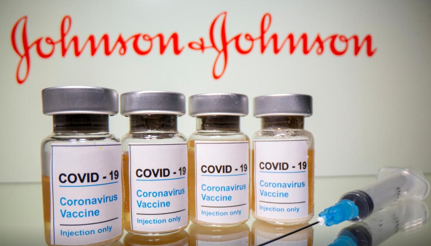 Vials with a sticker reading, "COVID-19 / Coronavirus vaccine / Injection only" and a medical syringe are seen in front of a displayed Johnson & Johnson logo in this illustration taken October 31, 2020. - Avaz