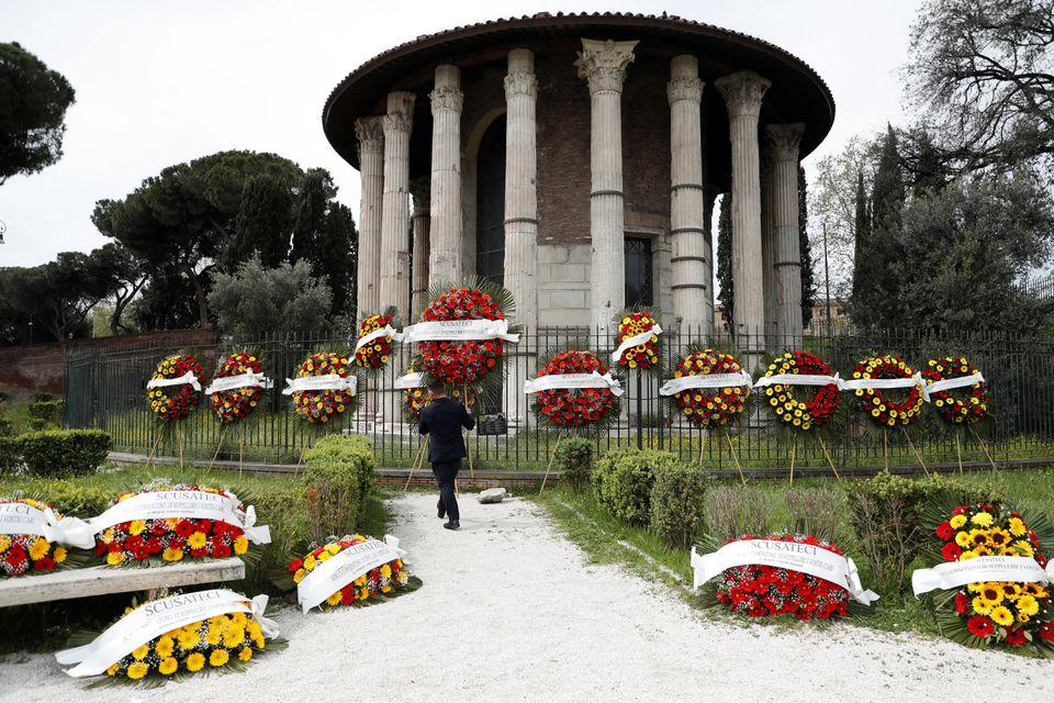 A man carries a funeral wreath with the words "Apologize but they don't let us bury your loved ones" written across it as them are laid out by funeral workers as Rome's cemeteries run out of space to store coffins ahead of funerals as a back-log in services due to coronavirus disease (COVID-19) restrictions has slowed down the pace for burials, in Rome, Italy, April 16, 2021. - Avaz