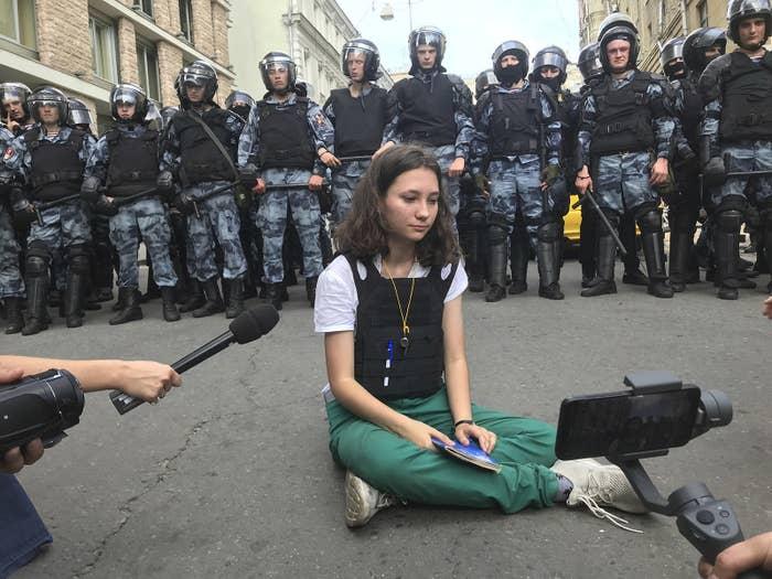 Olga Misik sits in front of police officers during an unsanctioned rally in the center of Moscow, July 27, 2019. - Avaz