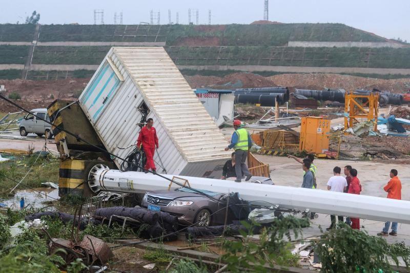 People look at damaged vehicles and structures at a construction site after a tornado hit an economic zone in Wuhan in China's central Hubei province on May 15. - Avaz