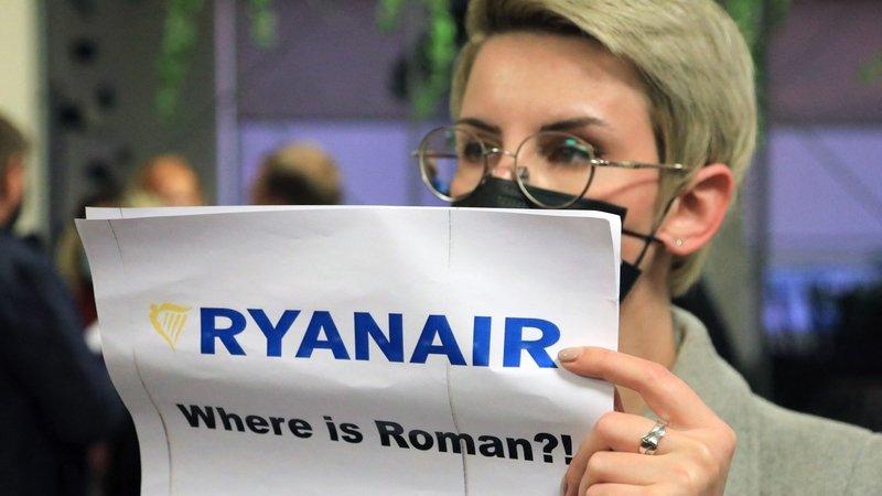 A woman stands with a poster reading 'Where is Roman (Protasevich)?' in the arrival area as passengers disembark from the diverted flight after arriving in Vilnius - Avaz