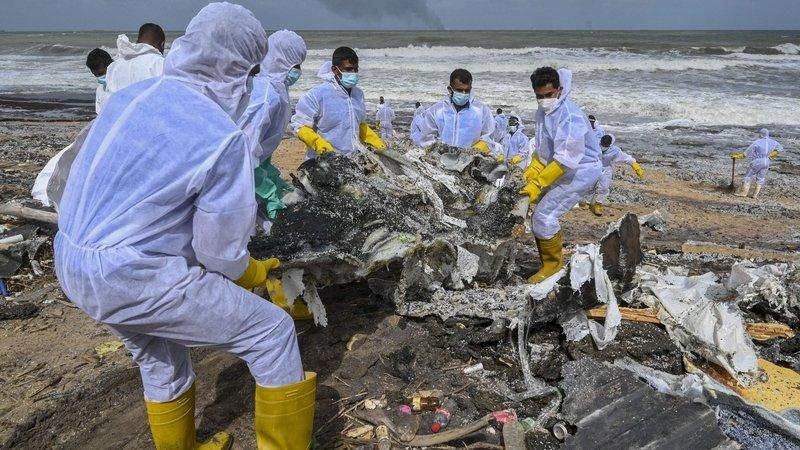 Members of the Sri Lankan navy work to remove debris washed ashore - Avaz