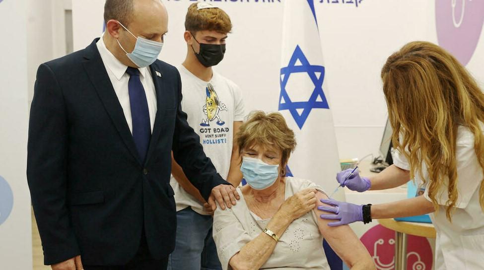 Israeli Prime Minister Naftali Bennett accompanies his mother Myrna as she receives a third Covid vaccine shot as part of the government's booster campaign for the over-60s - Avaz
