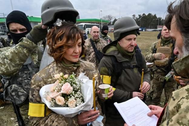 Vojnik drži Lesjin šlJem iznad glave da zaštiti njen veo tokom ceremonije - Avaz