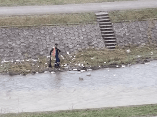 Radnik smeće sa obale gura u rijeku - Avaz