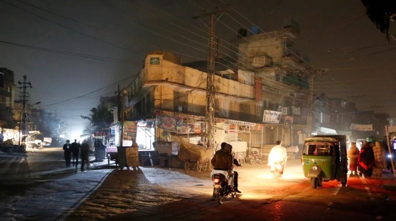 Vehicles headlights light a dark street during widespread power outages in Rawalpindi, Pakistan, Jan. 10, 2021. - Avaz
