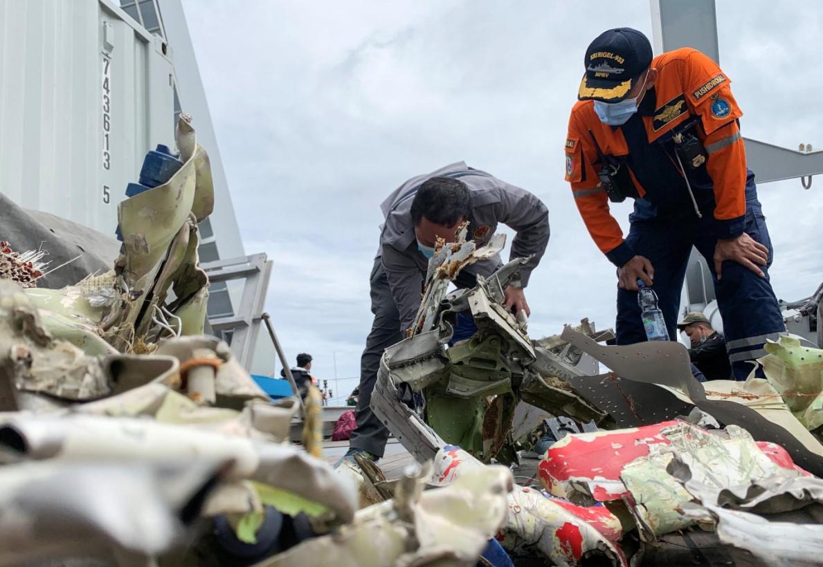 A National Transportation Safety Committee official (L) and a search and rescue agency member on board the navy ship KRI Rigel inspect debris retrieved from the sea floor during the search and rescue operation for Sriwijaya Air flight SJ 182 off the Jakarta coast, Indonesia, January 12, 2021. - Avaz