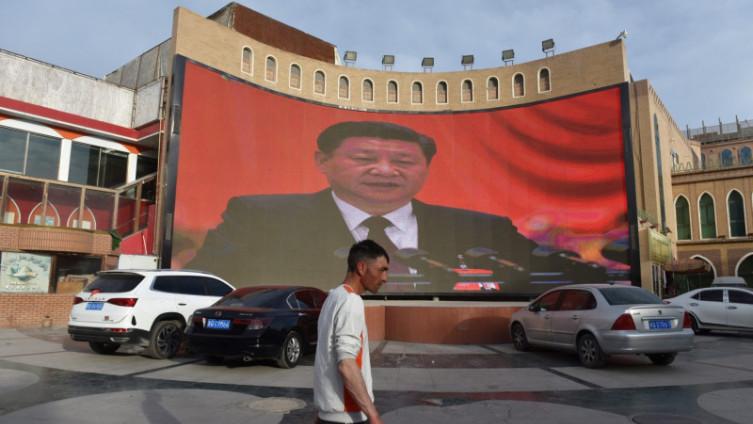 Ujgur hoda ispred platna s likom kineskog predsjednika Si Đipinga - Avaz