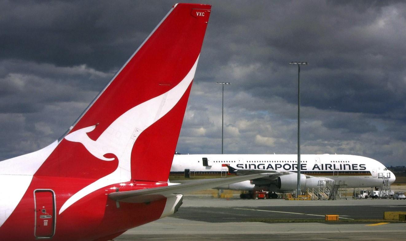 A Qantas Airways Boeing 737-800 plane passes a Singapore Airlines Airbus A380 at Sydney Airport March 17, 2014. - Avaz