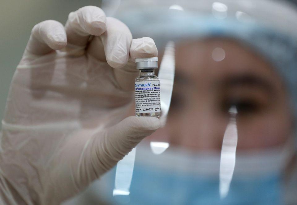 A medical worker poses for a picture while holding a vial with Sputnik V (Gam-COVID-Vac) vaccine against the coronavirus disease (COVID-19) at a mobile vaccination centre in the Palace of the Republic concert hall in Almaty, Kazakhstan April 2, 2021. - Avaz