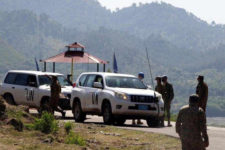 Pakistani soldiers stand guard as UN military observers pass by near the de facto border between India and Pakistan, on April 26, 2021. - Avaz