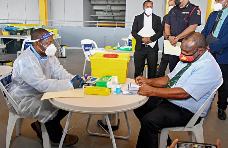 This photo taken on March 30, 2021 shows Papua New Guinea's Prime Minister James Marape (right) preparing to receive a dose of the AstraZeneca Covid-19 vaccine in Port Moresby, as Papua New Guinea's health minister on April 1 called disinformation spread on Facebook - Avaz