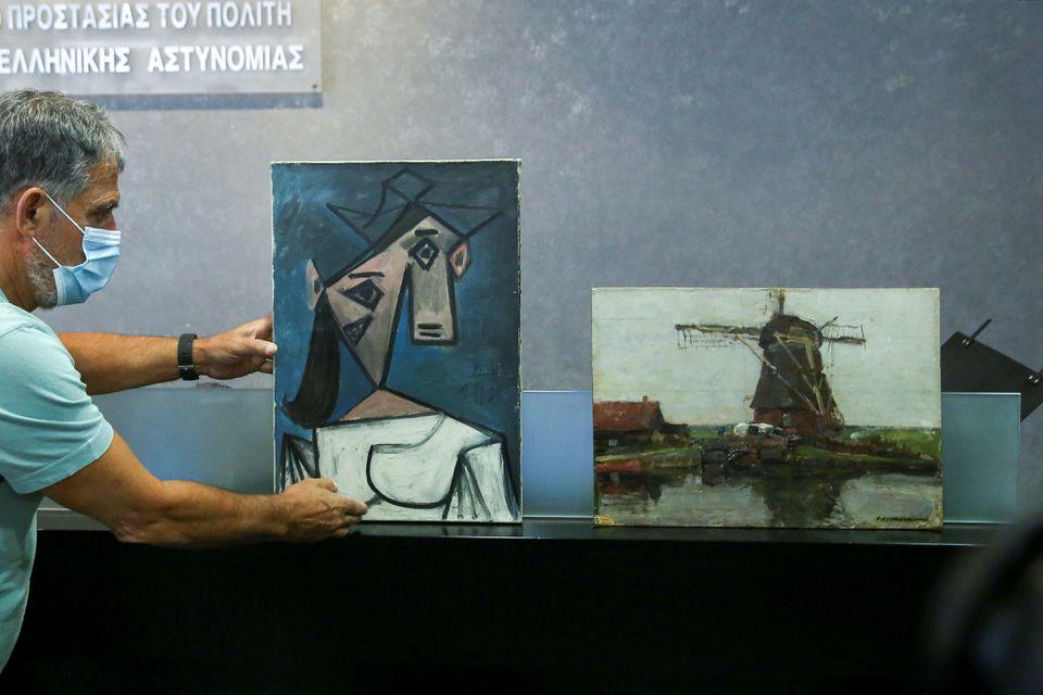 The paintings "Woman's Head" by Pablo Picasso and "Mill" by Piet Mondrian, both stolen from Greece's National Gallery in 2012, are displayed during a presentation to members of the media at the Ministry of Citizen Protection in Athens, Greece, June 29, 2021. - Avaz