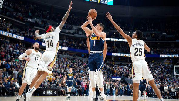 Denver Nuggets forward Michael Porter Jr., center, drives to the rim between New Orleans Pelicans forward Brandon Ingram, left, and guard Trey Murphy III in the first half of an NBA basketball game Tuesday - Avaz