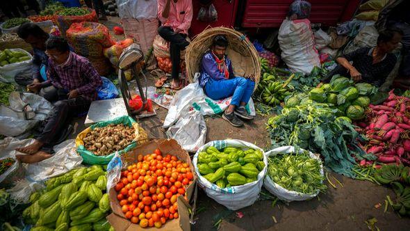 A vegetable seller takes rest at a wholesale vegetable market in Guwahati, India - Avaz