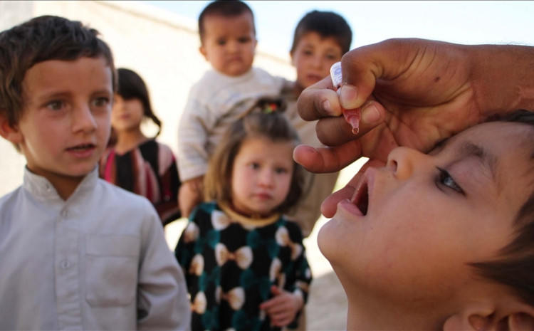 A health worker administers a polio vaccine to a child, out of Kabul Afghanistan
