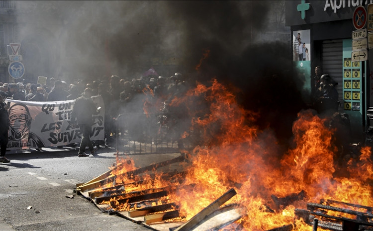 Protesters gather around a fire on the road during clashes with police on the sidelines of the annual May Day rally