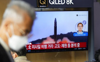 Televizijski ekran koji prikazuje informativni program koji izvještava o lansiranju projektila Sjeverne Koreje sa snimcima iz dosijea